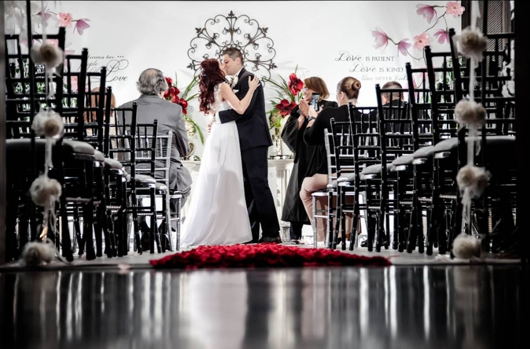 A couple shares their first kiss at the altar of The Courthouse Wedding Chapel in Houston, TX